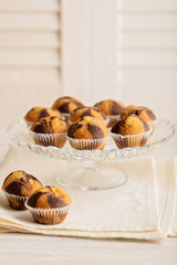 Muffins on a plate on light wooden background.