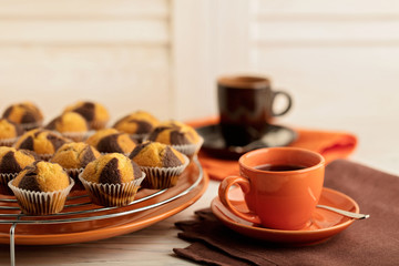 Coffee with milk and muffins on wooden background.