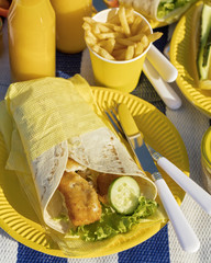 Summertime. A picnic on the beach. Burgers and pitas, vegetables and fruits.