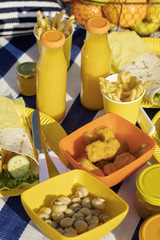 Summertime. A picnic on the beach. Burgers and pitas, vegetables and fruits. Selective focus.