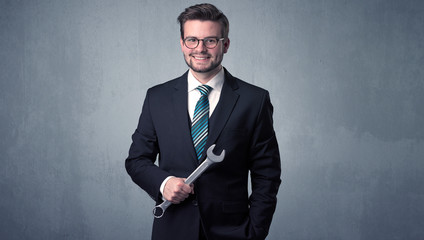 Businesman standing with tool on his hand