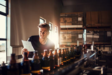 Worker checking the process on the production line in brewery fa