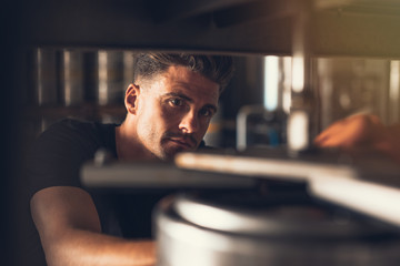 Brewer working on beer production line at brewery