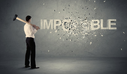 Obraz premium Business man hitting impossible sign with hammer