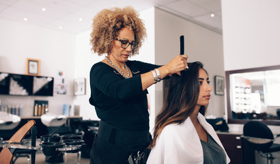 Woman hairdresser at work in salon - obrazy, fototapety, plakaty