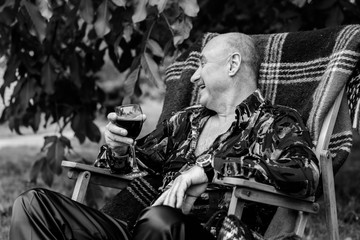 Obraz premium Happy stylish mature man resting on nature and smiling, having fun. Enjoy Life Pleasure Satisfaction Happiness Concept