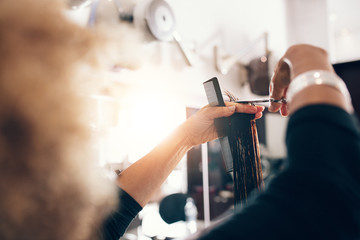 Close up of beautician's hand with a cutting hair of woman