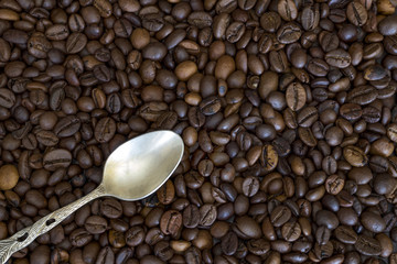 silver spoon in the corner and coffee beans as the background