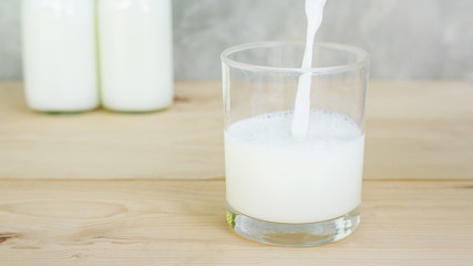 man pouring a milk on a wooden table.