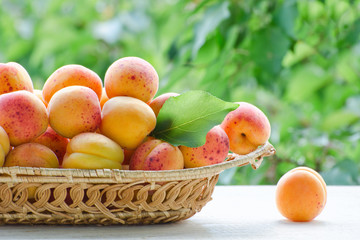 Wicker basket apricot on a green background, daylight