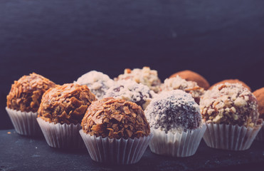 Set of different kinds of homemade chocolate truffles. Selective focus. Shallow depth of field. Toned