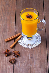 Glass of sea buckthorn beverage (kissel) on a brown wooden table or board for background. New year theme