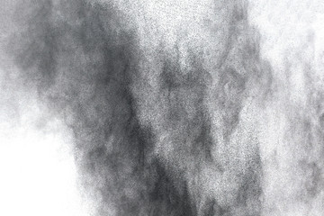 Black powder explosion. Closeup of black dust particles explode isolated on white background.