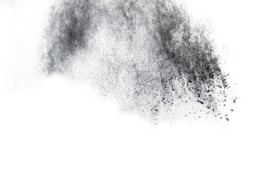 Black powder explosion. Closeup of black dust particles explode isolated on white background.