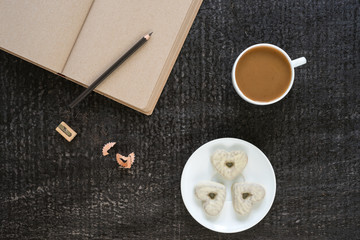 Fototapeta na wymiar Coffee, diary, pencil and heart-shaped cookies