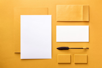 Brand identity mockup. Blank corporate stationery and set at golden textured foil background.
