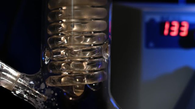 Crystal Spiral. Spiral glass tube with water close up. Glass spiral pipe from the reflux condenser with running water. fluid filtration in the laboratory experiment