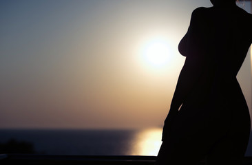 Silhouette of nude girl on sunset background