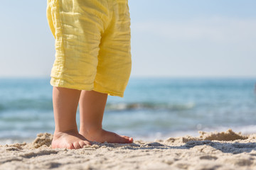 Beach,day,closeup of feet in shorts standing on the sand