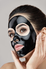 Woman Beauty Face Skin Mask. Girl Applying Black Peeling Product