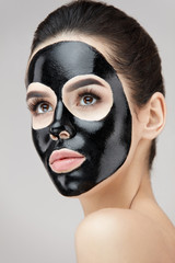 Beautiful Woman Face With Cosmetic Black Peeling Mask On Skin