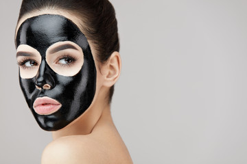 Beautiful Woman Face With Cosmetic Black Peeling Mask On Skin