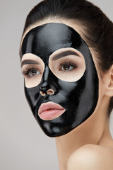 Beauty Face Black Mask. Woman With Black Cosmetic Mask On Skin