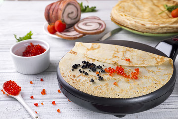 Pancakes in a frying pan with Salmon Caviar