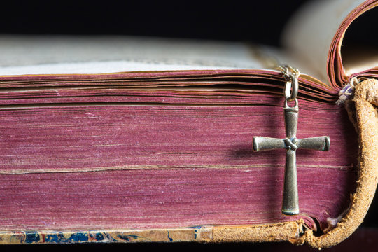 ein Buch mit einem christlichen Kreuz liegt auf einem Tisch