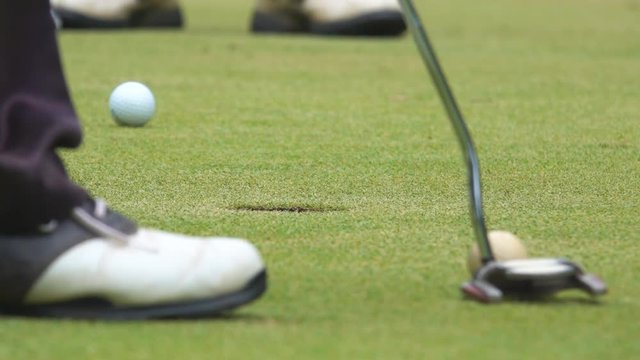 golfer putting golf ball to hole on green golf to the winner