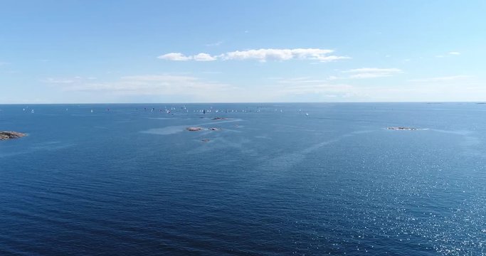 Sailboats on baltic sea, Cinema 4k aerial view above the baltic sea and towards a group of sailboats, out on the turquoise sea, on hango regatta day, in the finnish archipelago of Hanko, Finland