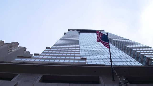American flag on a skyscraper in the financial district of New York City. Dolly shot.