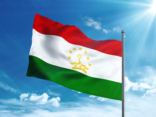 Fototapeta na wymiar Tajikistan flag waving in the blue sky