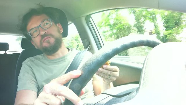 Funny man dancing eating hamburger while driving car 4K