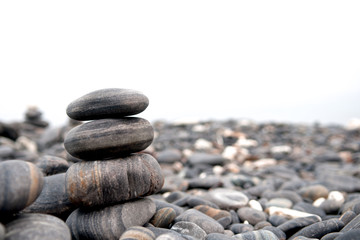 Fototapeta na wymiar Stones stack isolated on white background. Seashore and beach. Close up.