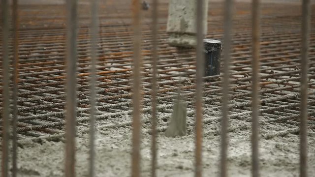 Pouring concrete mix from cement mixer on concreting formwork. Finished leveling the slab and pouring the concrete basement floor.