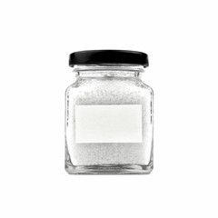 Salt in a glass bottle isolated on white background. Empty white stick note paper and black lid. Modern and stylish. Close up.