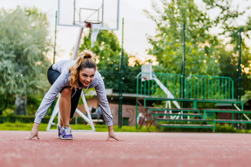 Athletic woman on running track getting ready to start run