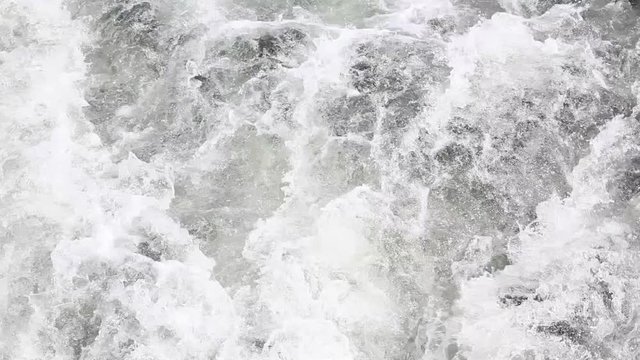 Turbulent flow of water after a boat or flowing from river or canal.