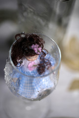 pretty pale doll in a wine glass