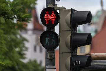 Red traffic light with a same-sex couple symbol in Munich to celebrate the pride week