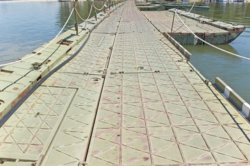 Military pontoon bridge over river