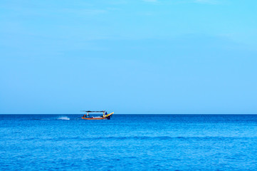 Small tropical fishing boat sailing back from the sea.