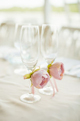 Glasses for newlyweds bride decorated with roses stand on table