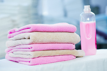 Rose detergent and heap of rose and beige towels