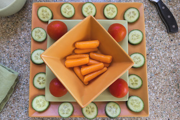 Fresh Carrots, Tomatoes and Cucumbers on Plates