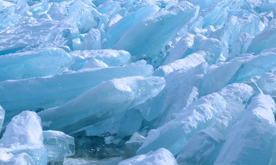 ice hummocks on the northern shore of Olkhon Island on Lake Baikal. Transparent blocks of crystal clear ice crawl ashore. Colorful refraction of rays of rising sun. Ice Storm. Photo partially tinted.