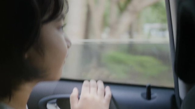 4K : Little girl looking from Window Car, Family Traveling on Countryside, Hand held shot
