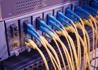 Fiber Optic cables connected to an optic ports and Network cables connected to ethernet ports