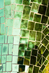 Mosaic of green glass tiles with air bubbles inside.